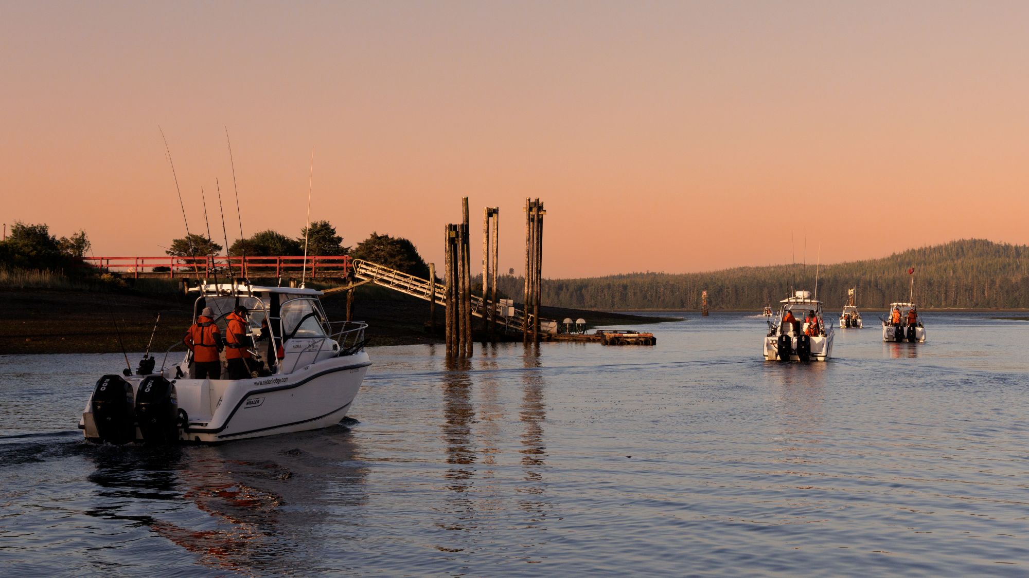 Sport fishing boats heading out on the water next to docks at sunrise
